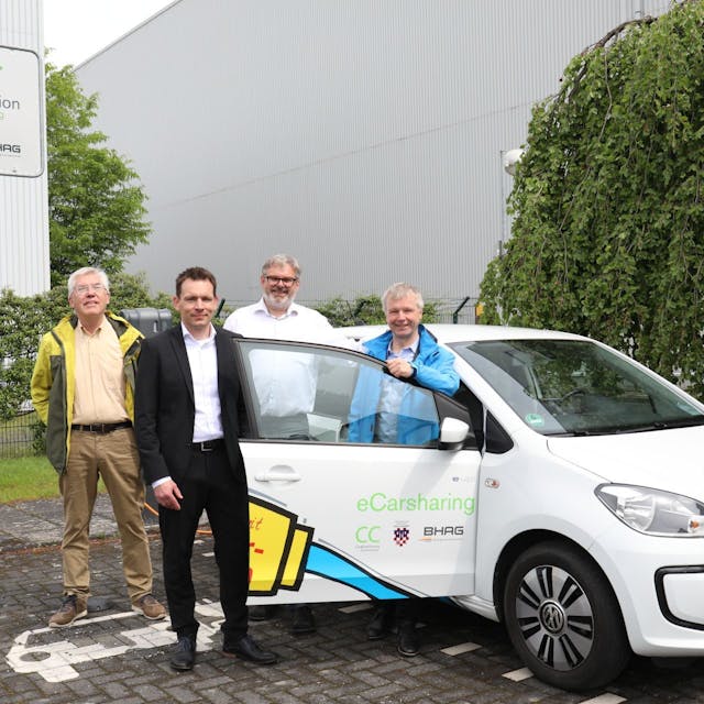 Gerhard Baumeister, Daniel Borchert, Stephan Reuter und Bürgermeister Otto Neuhoff posieren neben einem Elektrofahrzeug.