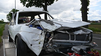 Das Bild zeigt einen im Frontbereich beschädigten weißen VW-Golf I.