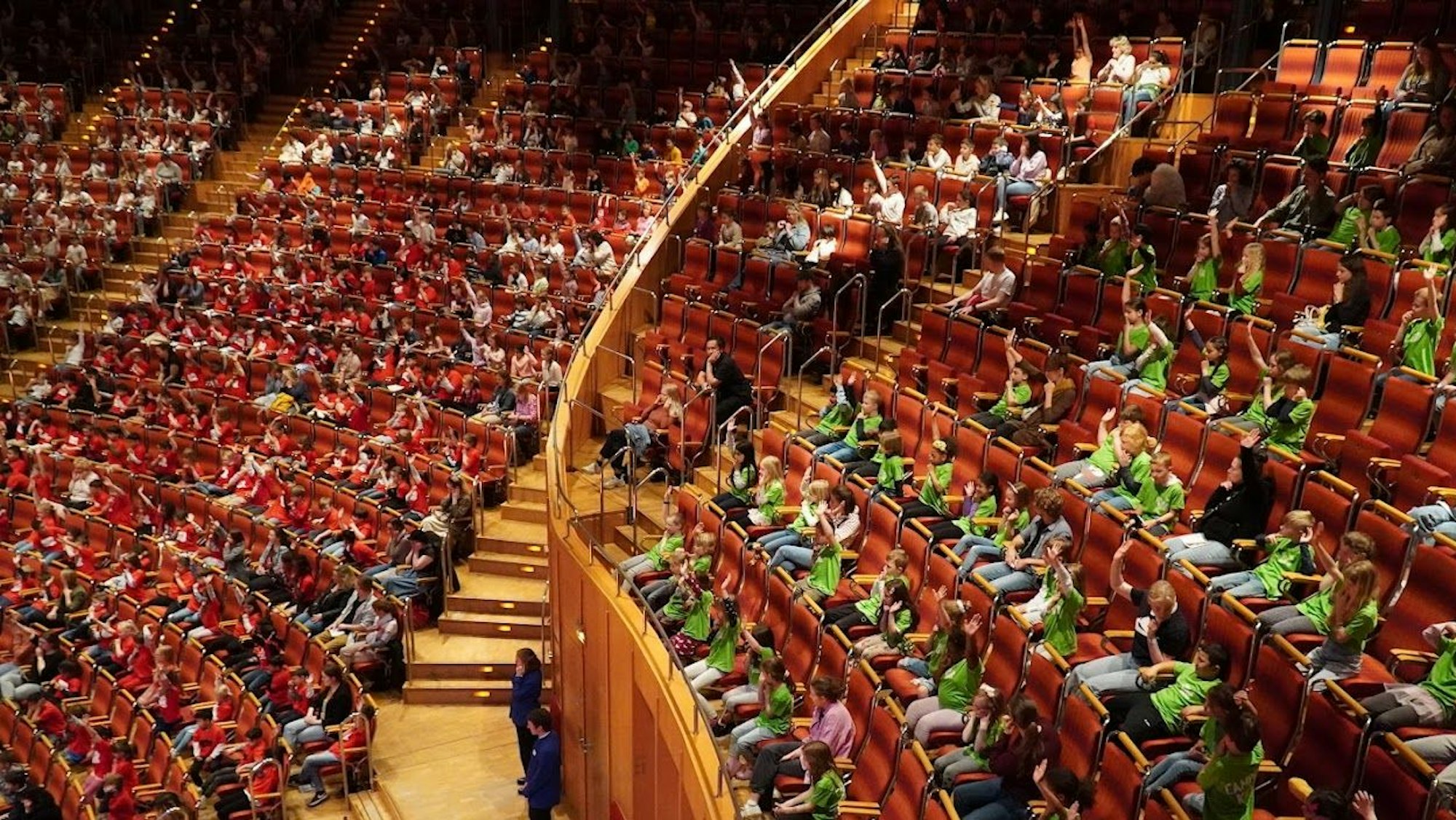 Grundschulkinder in farbigen T-Shirts sbelagern die Publikumsreihen der Kölner Philharmonie, mehr als 1500 waren es insgesamt beim Abschlusskonzert des „Singpause“-Projekts.