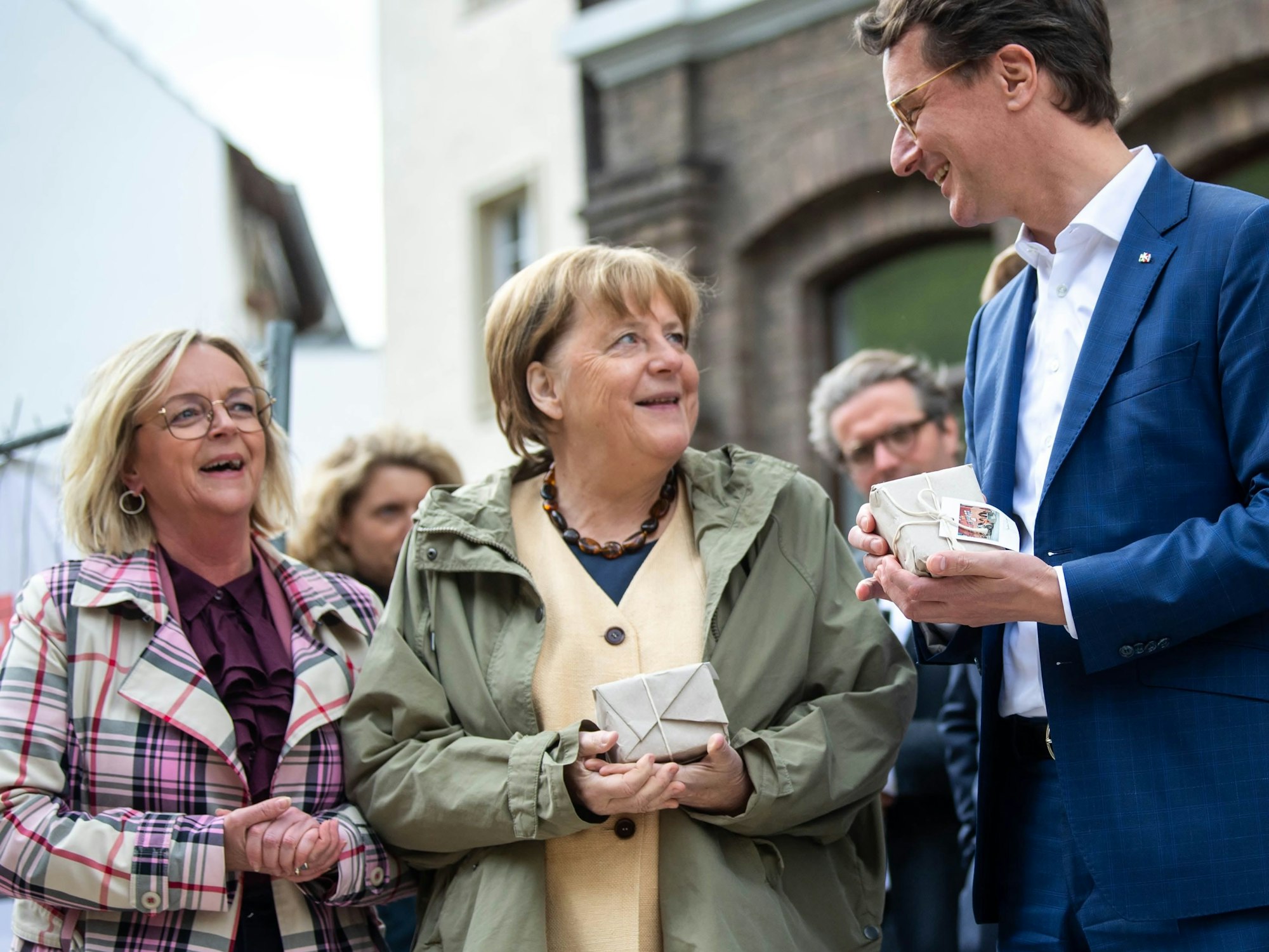 NRW-Ministerpräsident Hendrik Wüst und Ex-Bundeskanzlerin Angela Merkel erhielten von Bad Münstereifels Bürgermeisterin Sabine Preiser-Marian einen bemalten Pflasterstein.
