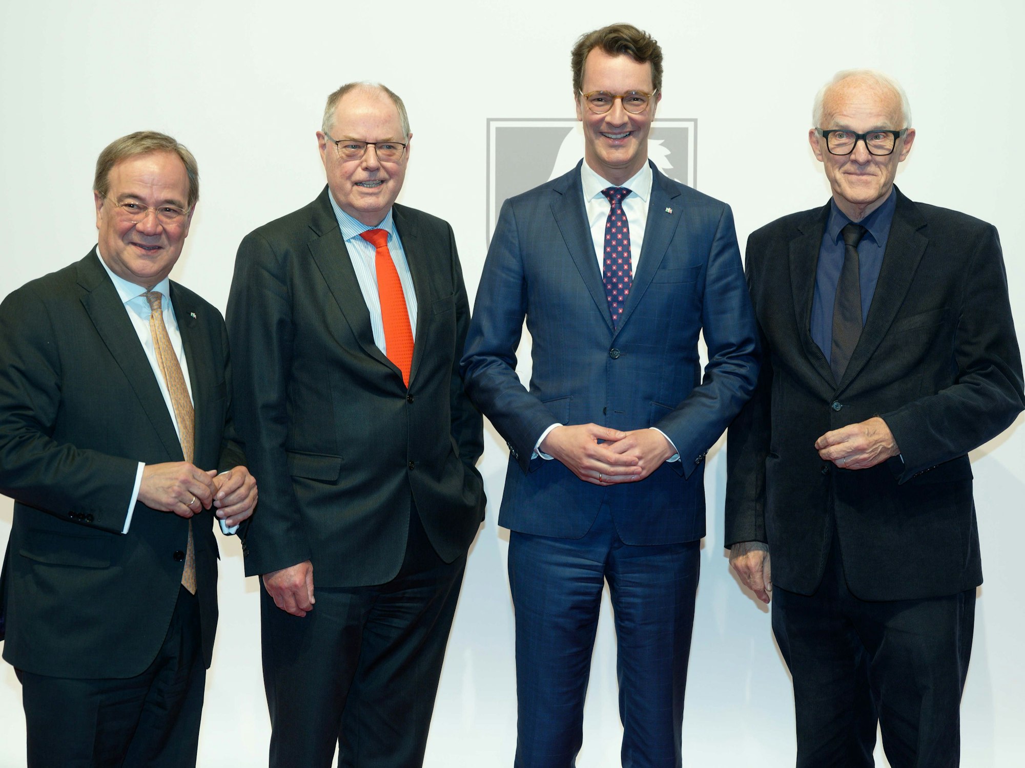 Die ehemaligen Ministerpräsidenten von Nordrhein-Westfalen Armin Laschet (CDU) und Peer Steinbrück (r), der Amtierende Ministerpräsident Hendrik Wüst (CDU) und der ehemalige Ministerpräsident Jürgen Rüttgers stehen vor der Verleihung des NRW-Staatspreises vor einer Fotowand.