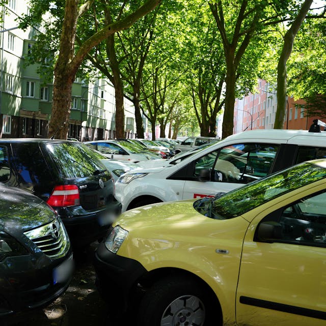 Autos stehen dicht gedrängt auf dem Mittelstreifen einer Straße.
