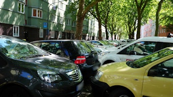 Autos stehen dicht gedrängt auf dem Mittelstreifen einer Straße.