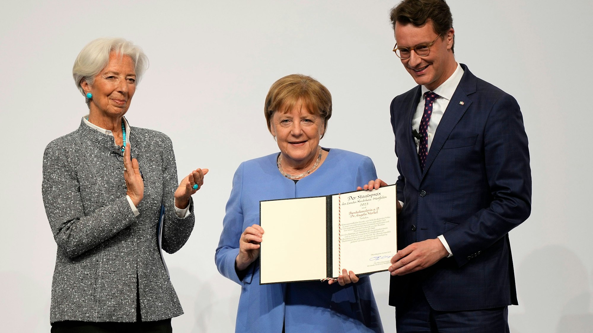 Die frühere Kanzlerin Angela Merkel (Mitte) neben Hendrik Wüst, Ministerpräsident von Nordrhein-Westfahlen (rechts) und Christine Lagarde, Präsidentin der Europäischen Zentralbank (links)