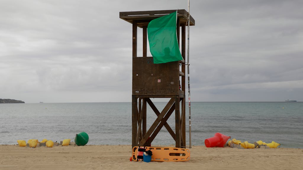 Ein Rettungsschwimmer sitzt auf dem Wachturm am Strand von Palma de Mallorca.