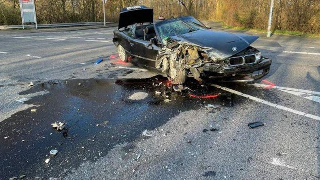 Ein zerstörter BMW liegt alleine auf einer Straße in Köln.