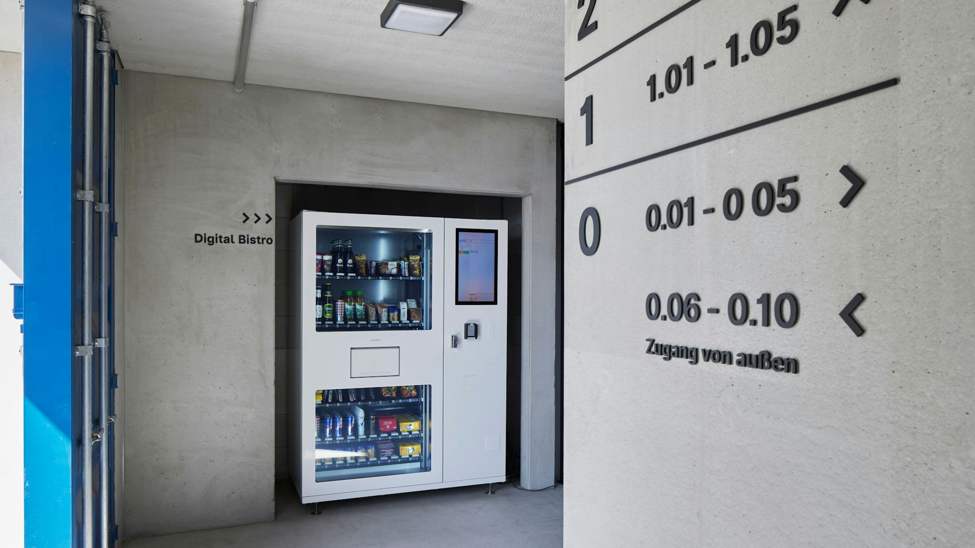 Ein Getränke- und Snack-Automat ist in die Betonwand eingelassen.