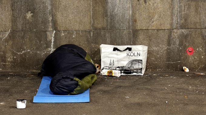 Ein Mann schläft in der Nähe des Kölner Hauptbahnhofs in einer Unterführung.