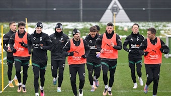 Die Spieler von Borussia Mönchengladbach laufen im Training am Borussia-Park eine Runde.