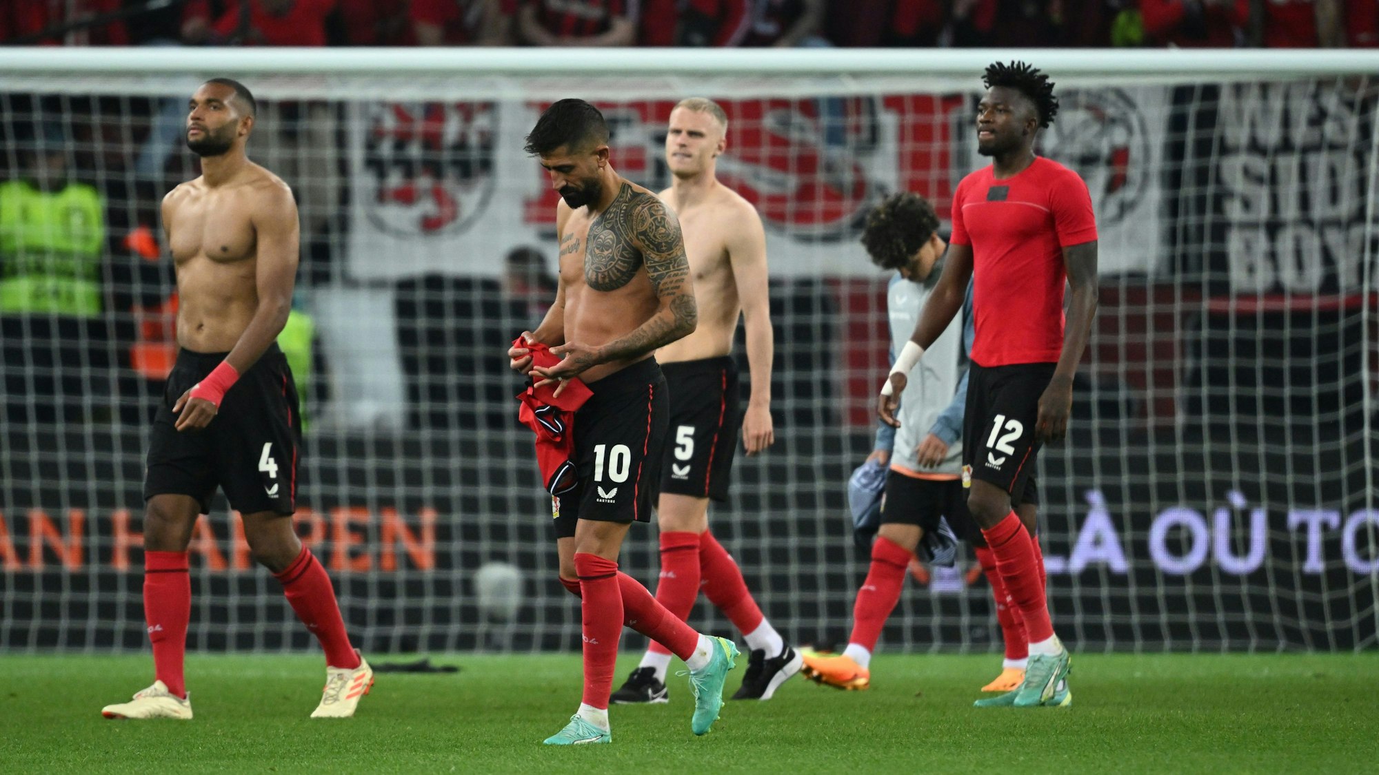 Leverkusens Jonathan Tah, Kerem Demirbay, Mitchel Bakker und Edmond Tapsoba verlassen nach der Partie das Spielfeld.