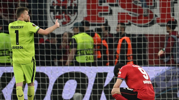 Leverkusens Torhüter Lukas Hradecky und Sardar Azmoun (r) reagieren nach der Partie.