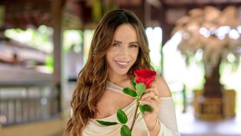 Das Foto zeigt Bachelorette Jennifer Saro, die lächelnd mit einer Rose in der Hand posiert.&nbsp;