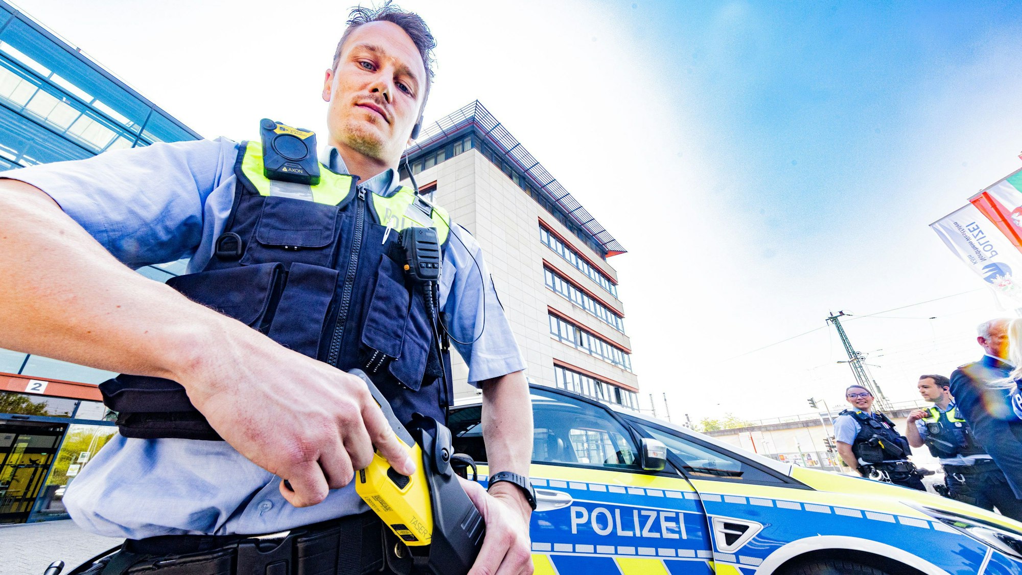 Ein Polizist zückt seine Elektro-Pistole.