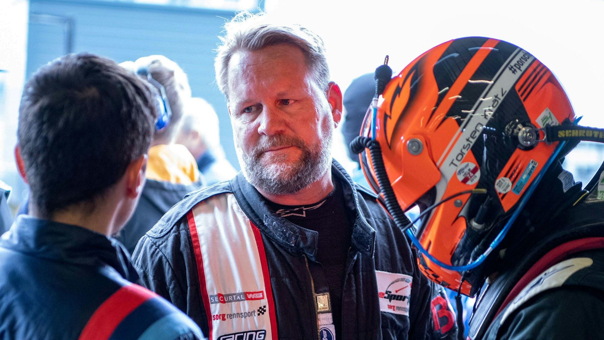 Björn Simon unterhält sich mit Technikern und anderen Rennfahrern.