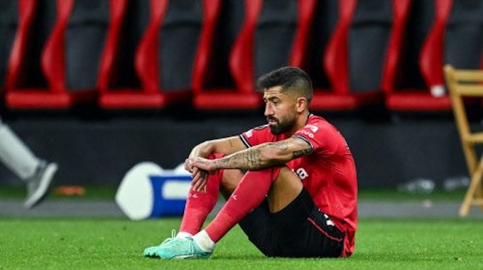 Kerem Demirbay von Bayer Leverkusen sitzt enttäuscht am Boden.