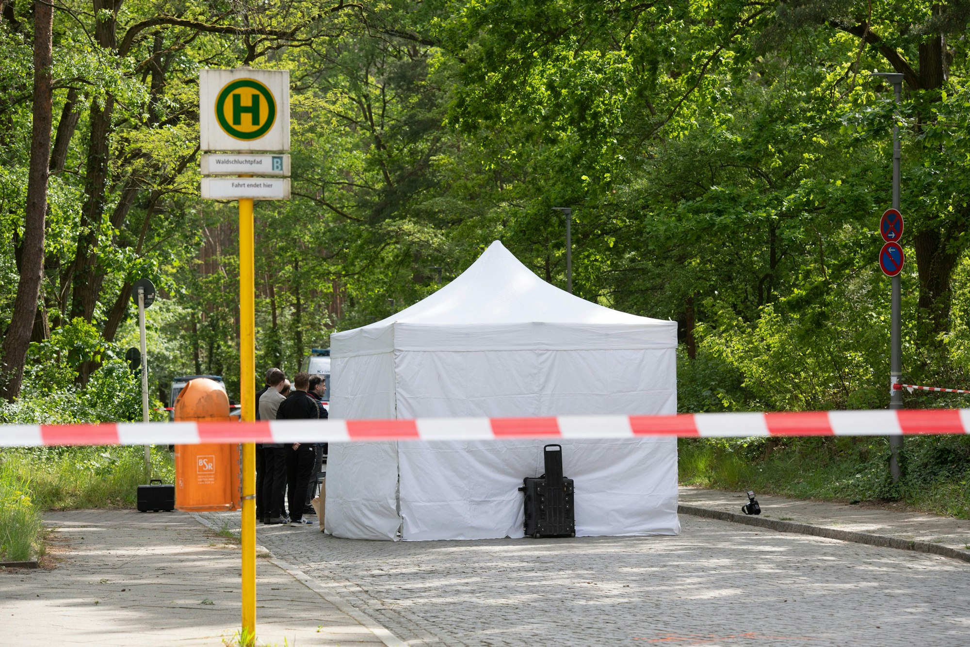 Ein Untersuchungszelt steht an einer Bushaltestelle in Berlin-Gatow. Darunter liegt die Leiche eines Mannes, der gegen Mittag erschossen worden war.