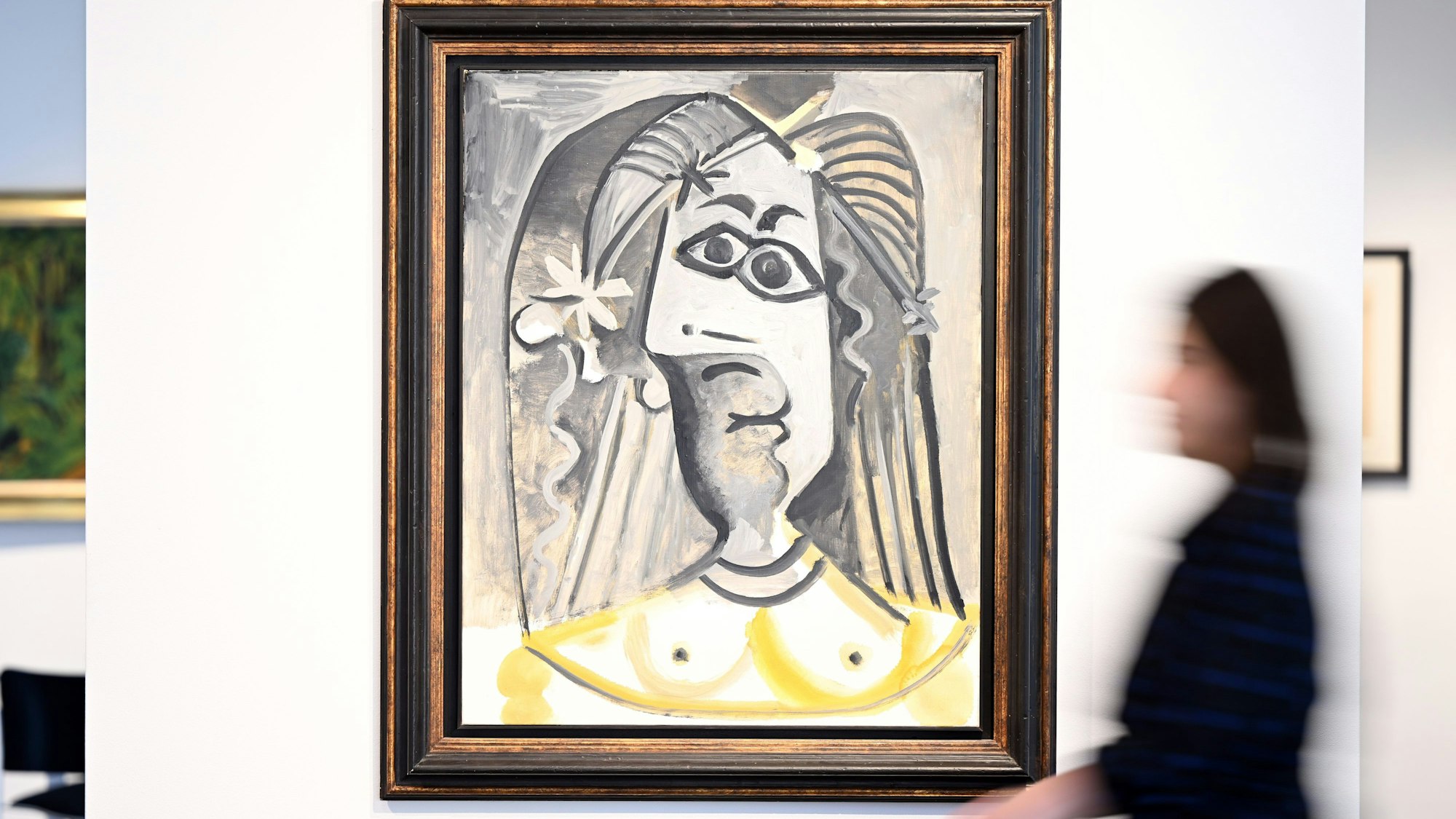 Eine Mitarbeiterin des Auktionshauses Van Ham geht am Bild "Buste de femme" aus dem Jahr 1971 von Pablo Picasso vorbei.