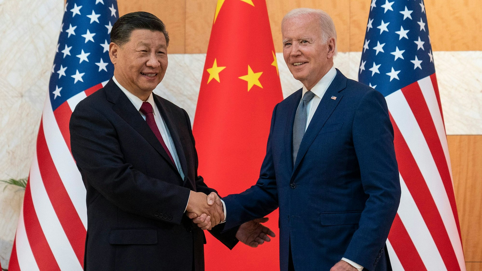 Chinas Präsident Xi gibt US-Präsident Joe Biden die Hand.