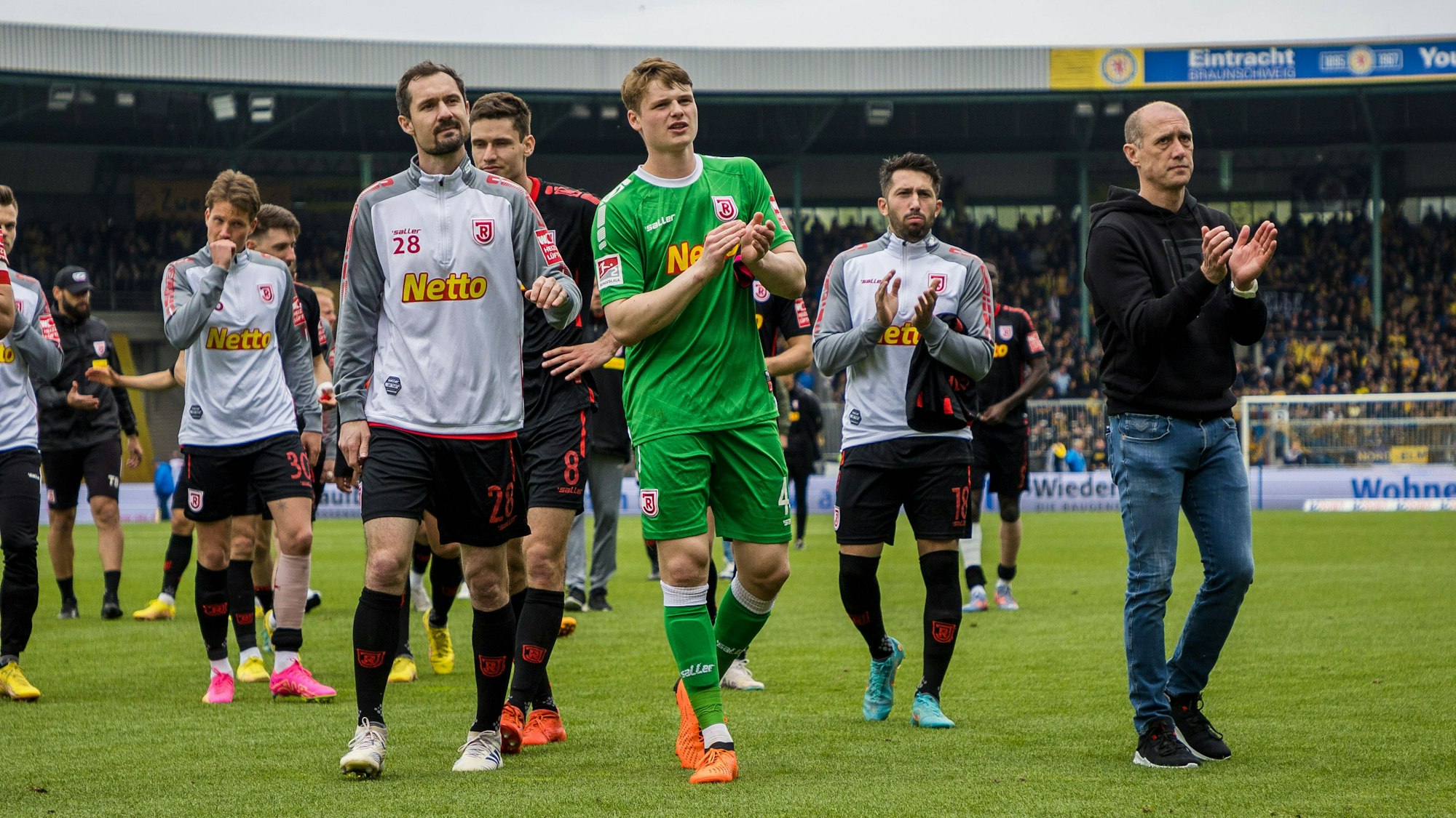 Der SSV Regensburg lässt sich von seinen Fans nach dem 2:1 Auswärtssieg gegen Braunschweig am 20. Mai 2023 trösten.