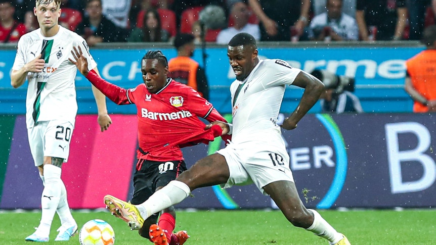 Borussia Mönchengladbach hat am Sonntag (21. Mai 2023) 2:2 bei Bayer 04 Leverkusen gespielt. Das Foto zeigt Leverkusens Jeremy Frimpong (l.) im Zweikampf mit Gladbachs Marcus Thuram (r.).