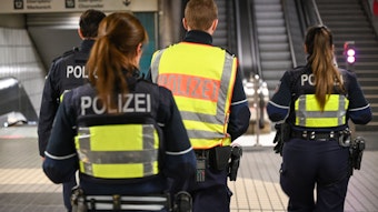 Vier Beamte und Beamtinnen der Polizei patrouillieren in einer U-Bahn-Station.