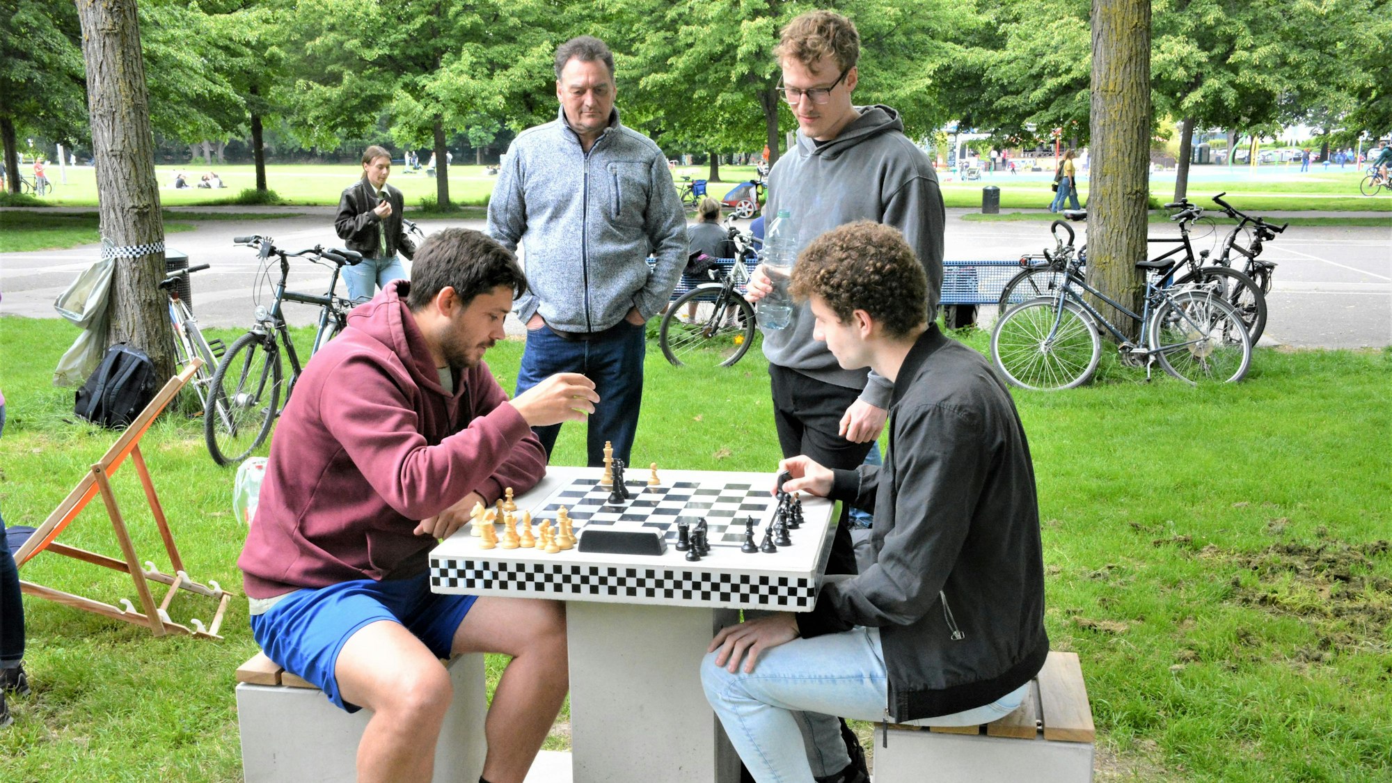 Zwei Männer sitzen im Inneren Grüngürtel vor einem Schachbrett.