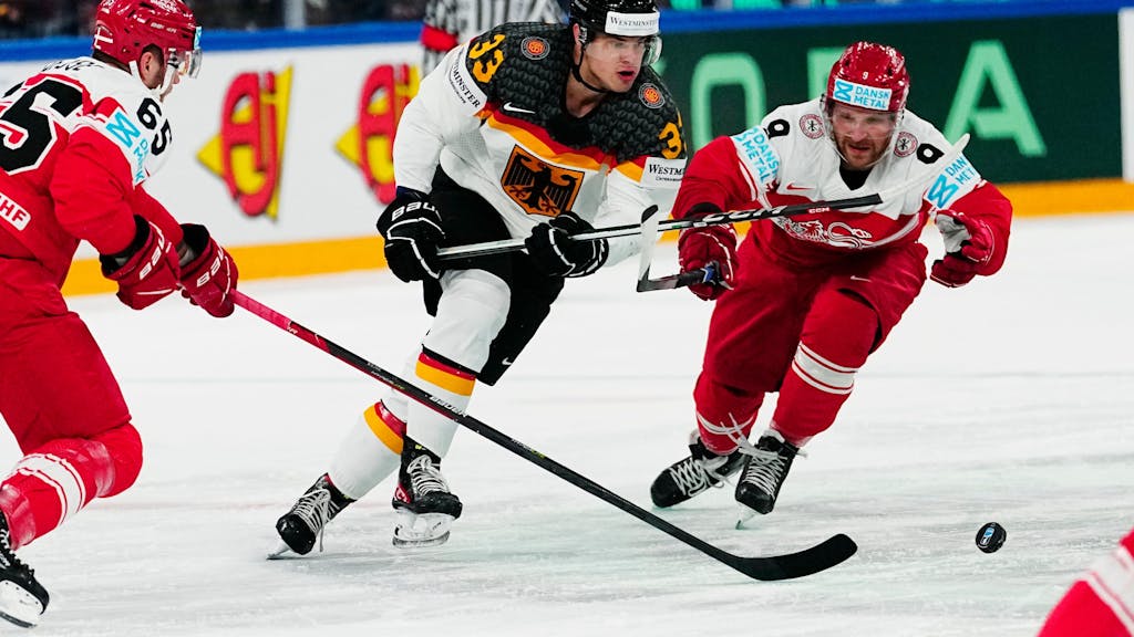 John Peterka bei der Eishockey-WM im Zweikampf mit zwei dänischen Gegenspielern.