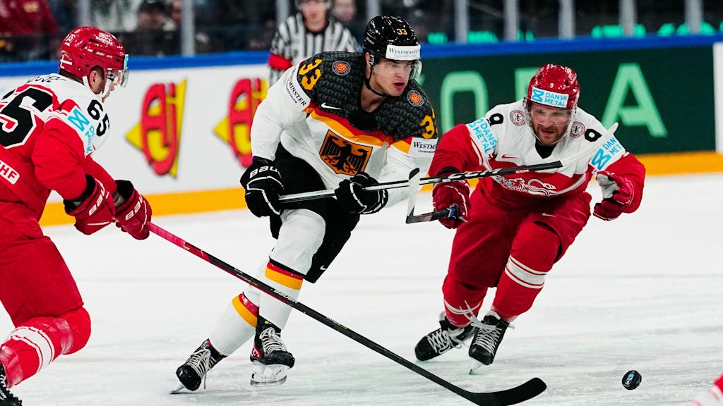 John Peterka bei der Eishockey-WM im Zweikampf mit zwei dänischen Gegenspielern.