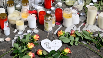 Kerzen erinnern vor einem Hochhaus in Ratingen an die zahlreichen verletzten Rettungskräfte nach einer bewusst herbei geführten Explosion in dem Gebäude.