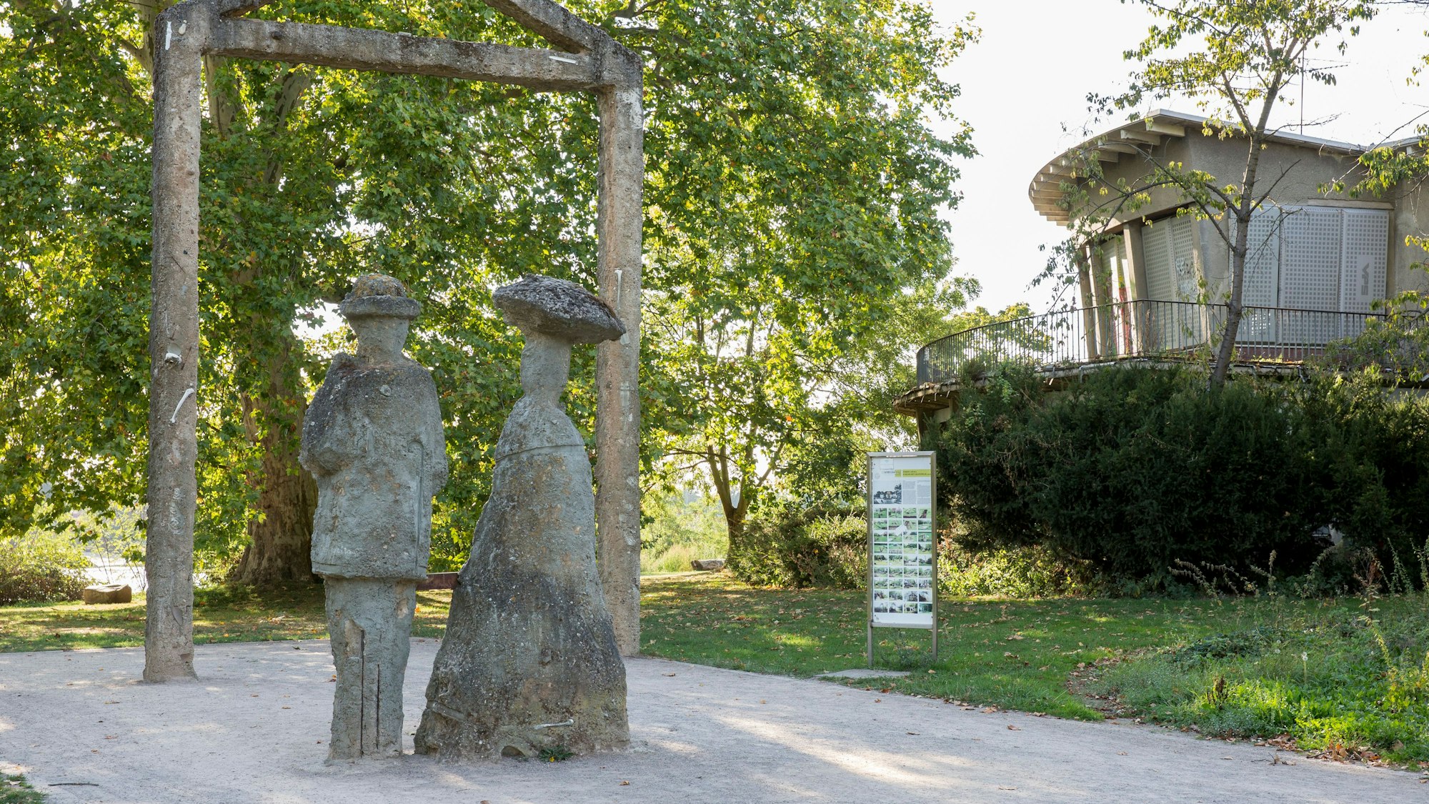 zwei Skulpturen aus Stein stehen auf einem Weg