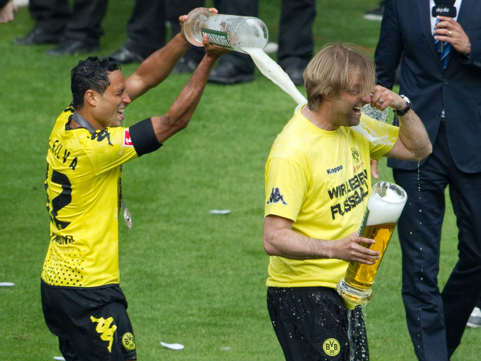Der Dortmunder Antonio da Silva begießt Trainer Jürgen Klopp nach der Siegerehrung mit Bier.