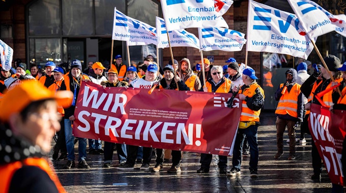 Demonstrierende der Eisenbahn- und Verkehrsgewerkschaft (EVG) protestieren am 27. März mit Plakaten vor dem Bremer Hauptbahnhof. Seit Monaten streiten die Gewerkschaft und die Deutsche Bahn um die Löhne.