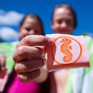 Zwei Mädchen halten ihre Seepferdchen-Abzeichen in den Händen.