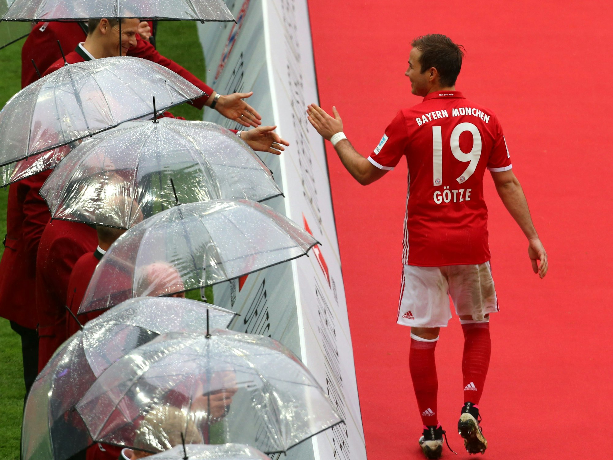 Bayerns Mario Götze klatscht auf dem Weg zur Übergabe der Meisterschale die ehemaligen Meister-Spieler des FC Bayern München ab.