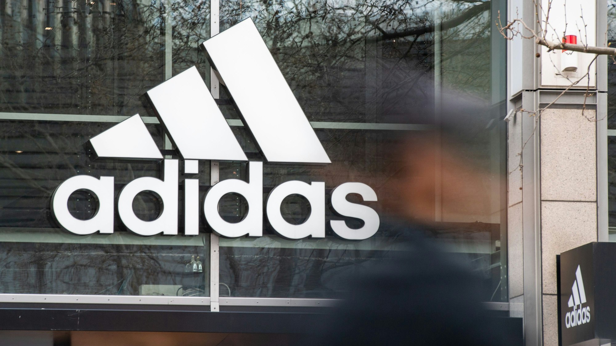 An derFassade des Adidas Stores hängt das Logo des Unternehmens.
