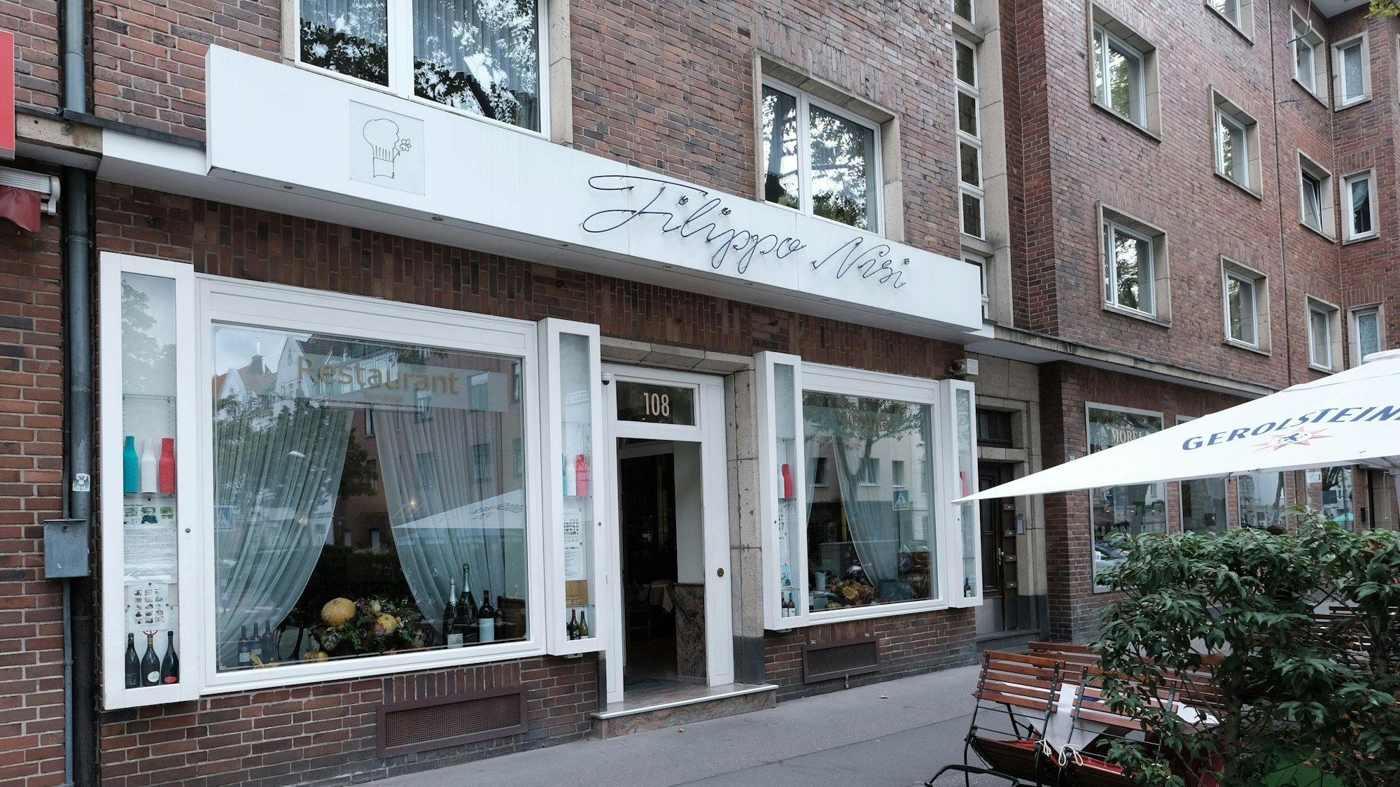 Blick von außen auf die weißen Fenster des Filippo Nisi, ein italienisches Restaurant in Köln.