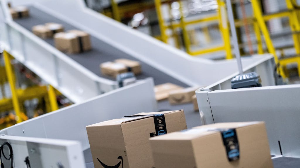Pakete des Paketversenders Amazon laufen im Sortierzentrum über die Bänder.