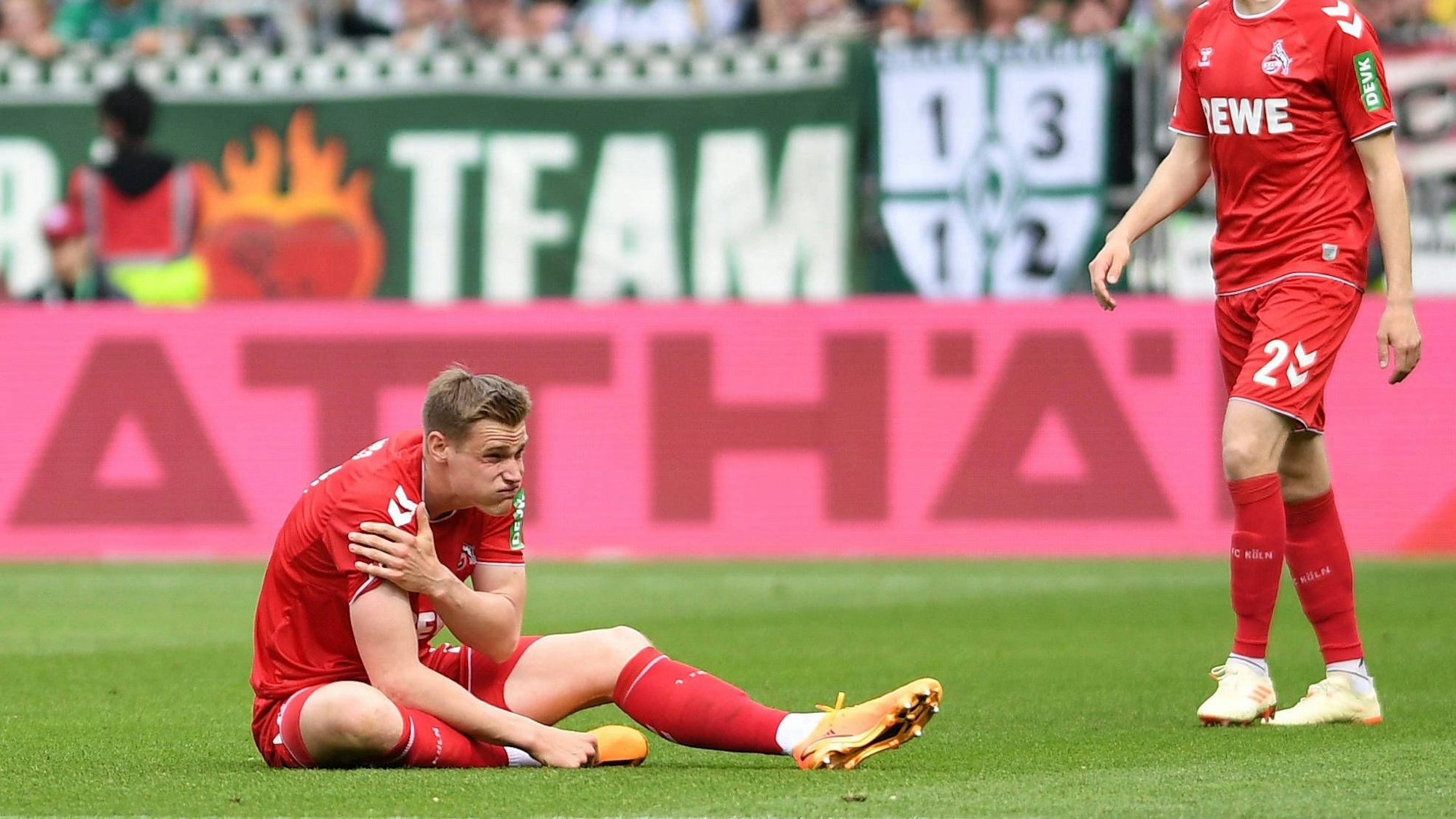 Mit schmerzverzerrtem Gesicht sitzt FC-Angreifer Steffen Tigges auf dem Rasen des Weserstadions und hält sich die rechte Schulter.