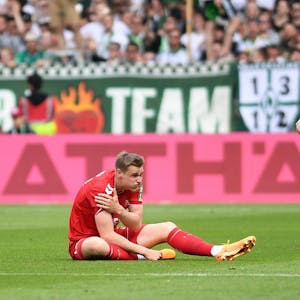 Mit schmerzverzerrtem Gesicht sitzt FC-Angreifer Steffen Tigges auf dem Rasen des Weserstadions und hält sich die rechte Schulter.