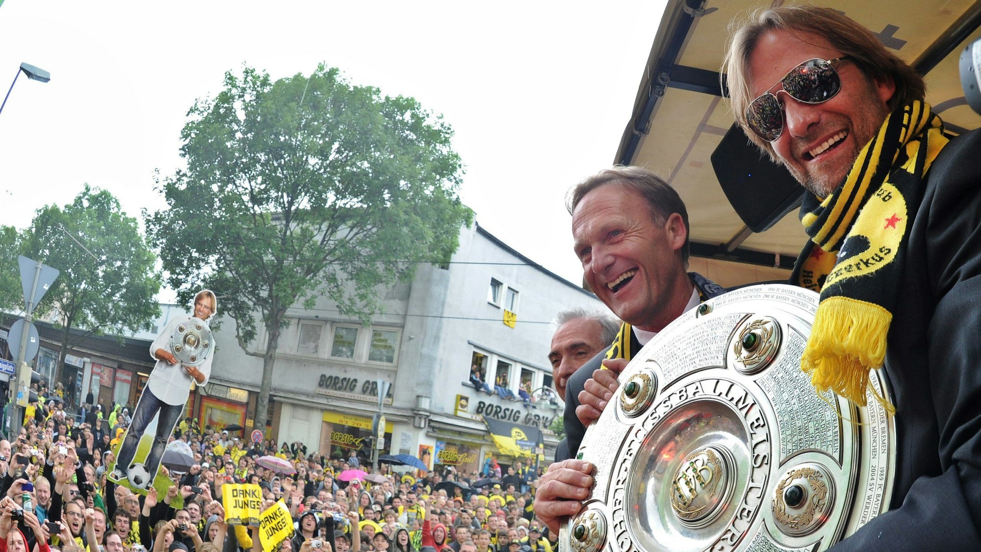 Dortmunds damaliger Trainer Jürgen Klopp (r.) mit der Meisterschale und Dortmunds Geschäftsführer Hans-Joachim Watzke feiern am 15. Mai 2011 auf einem Umzugswagen in einem Autokorso auf dem Borsigplatz die Meisterschaft in Dortmund.