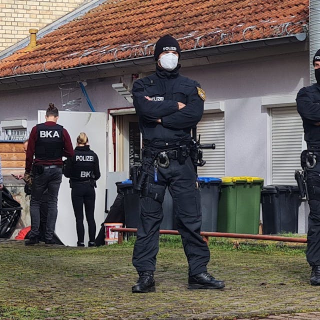 Polizisten sichern den Hintereingang eines Gebäudes: Die vier Gründer der rechtsextremistischen Terror-Gruppe Knockout 51 wurden verhaftet.