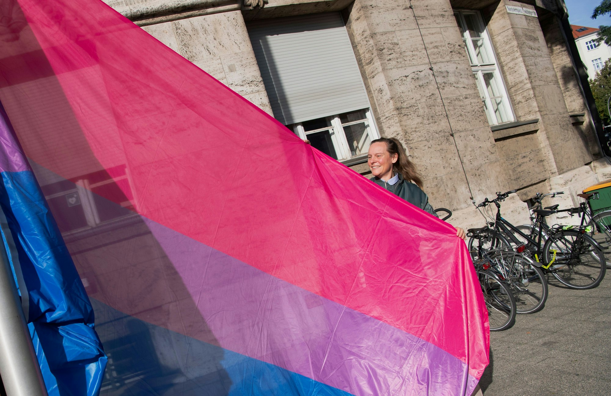 Lena Kreck (Die Linke), Berlins Senatorin für Justiz, Vielfalt und Antidiskriminierung, hisst mit einer Vertreterin des Vereins „BiBerlin“ zum internationalen Tag der Bisexualität vor ihrem Dienstgebäude die „Bi-Flag“.