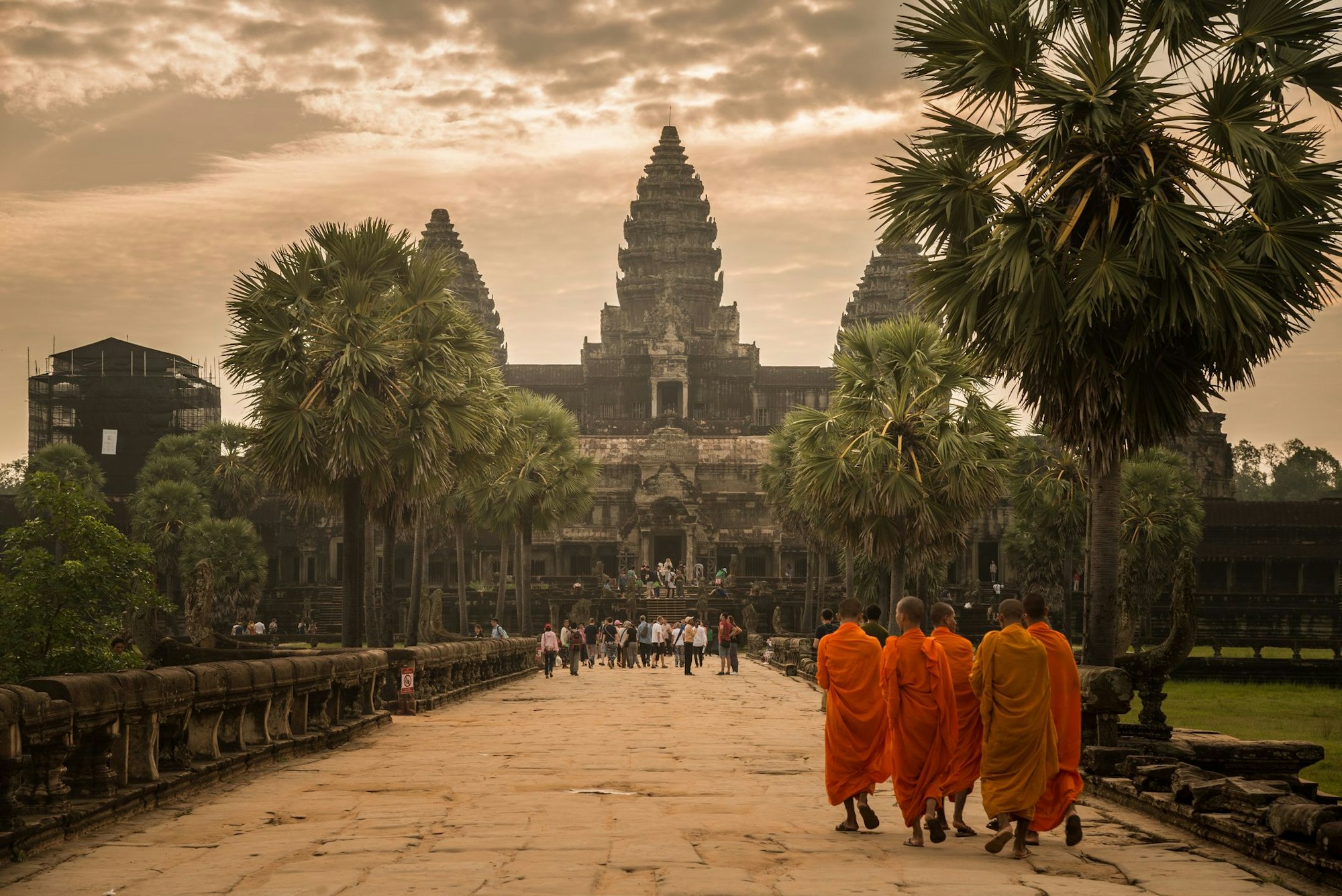 Drei Mönche laufen auf den Tempel zu.