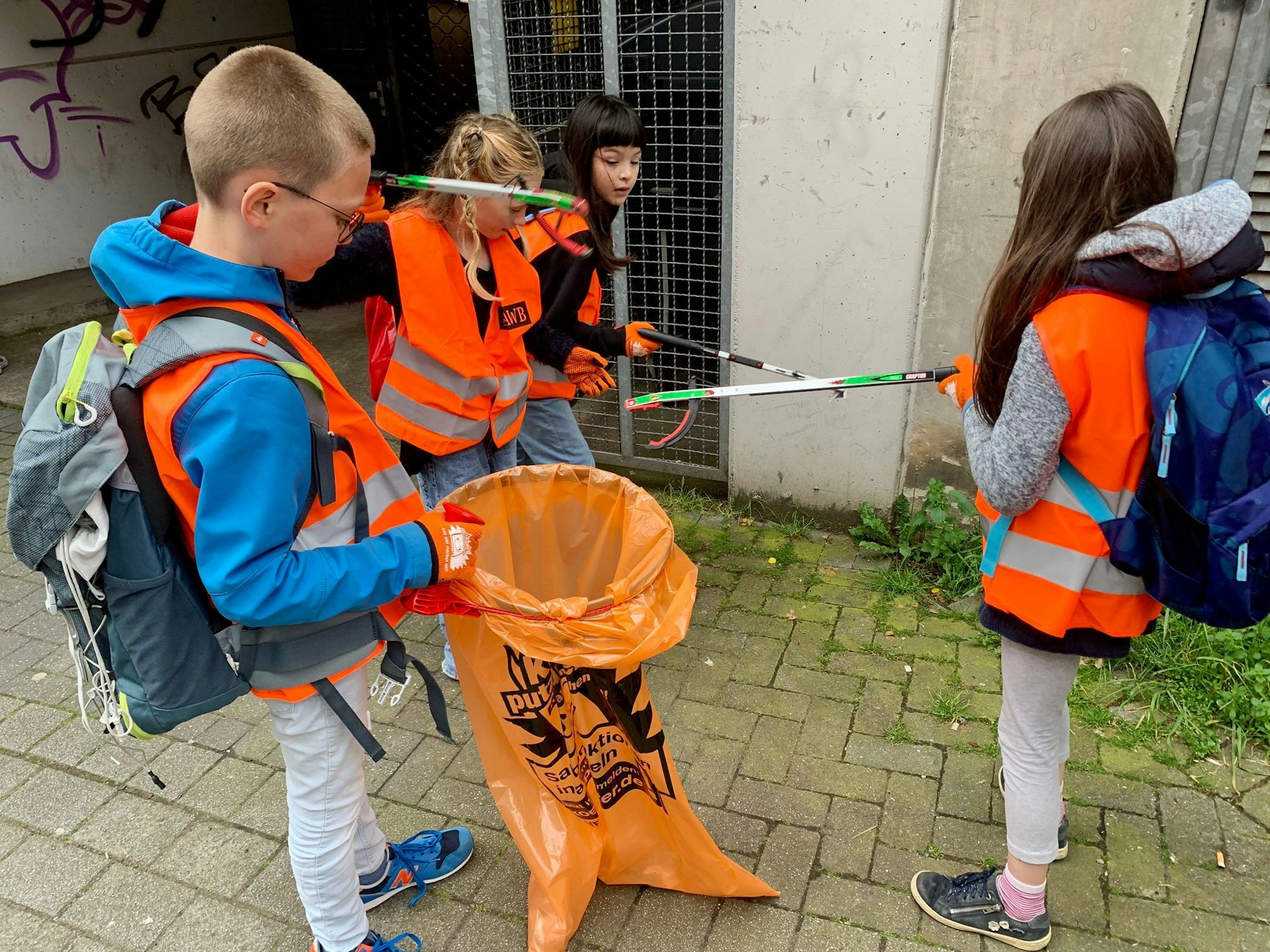 Schülerinnen und Schüler sammeln Müll in Köln auf.