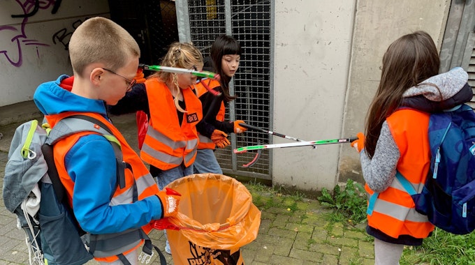 Schülerinnen und Schüler sammeln Müll in Köln auf.