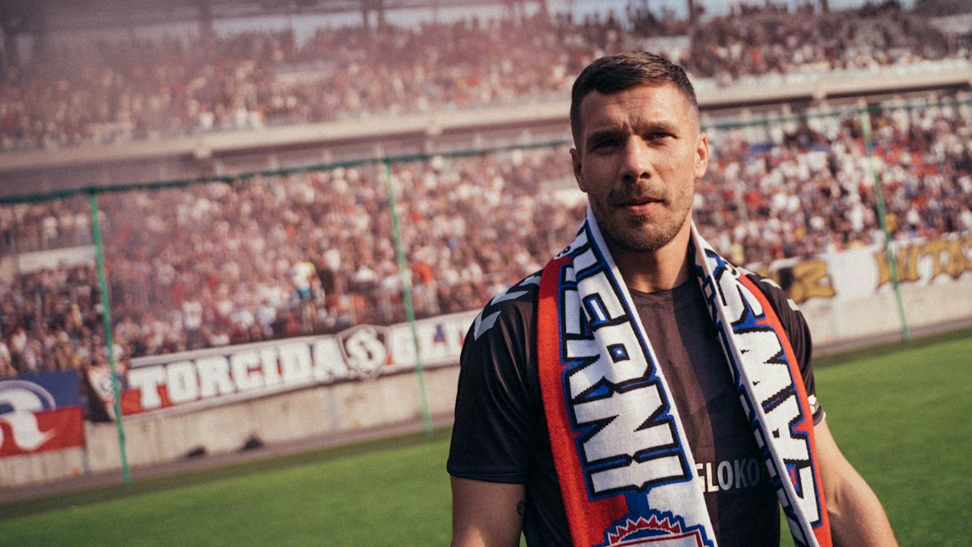 Lukas Podolski mit Fan-Schal im Stadion seines Heimatvereins Gornik Zabrze