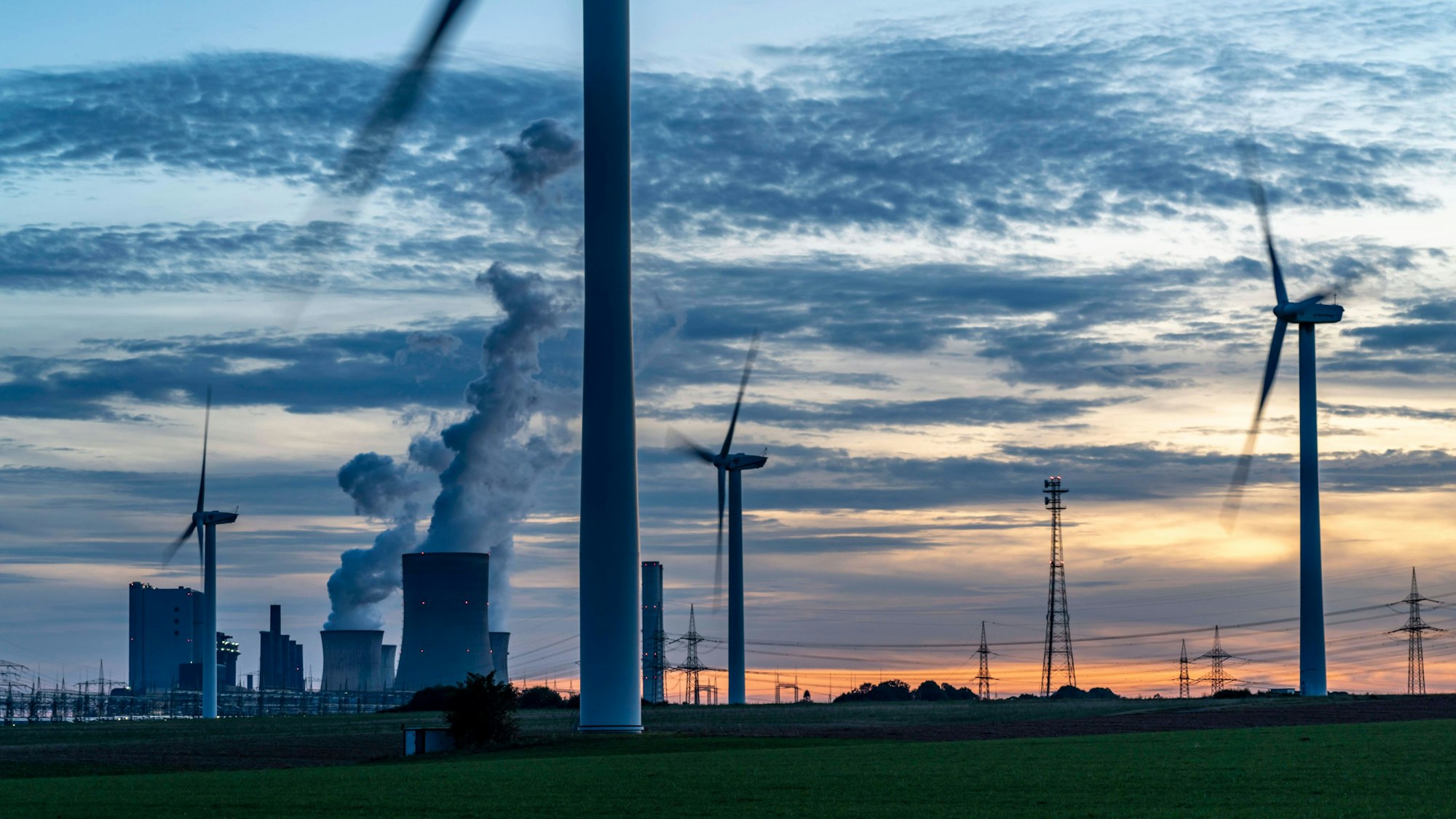 Braunkohle Kraftwerk, RWE Power AG Kraftwerk Niederaußem und Windkraftwerke sind im Sonnenuntergang zu sehen.