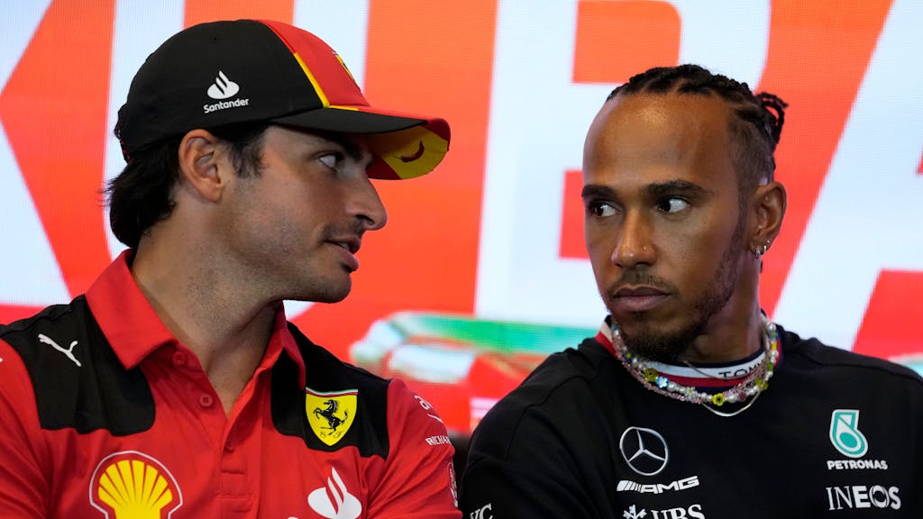 Carlos Sainz (l) aus Spanien vom Team Scuderia Ferrari unterhält sich mit Lewis Hamilton aus Großbritannien vom Team Mercedes-AMG Petronas Motorsport während einer Pressekonferenz.