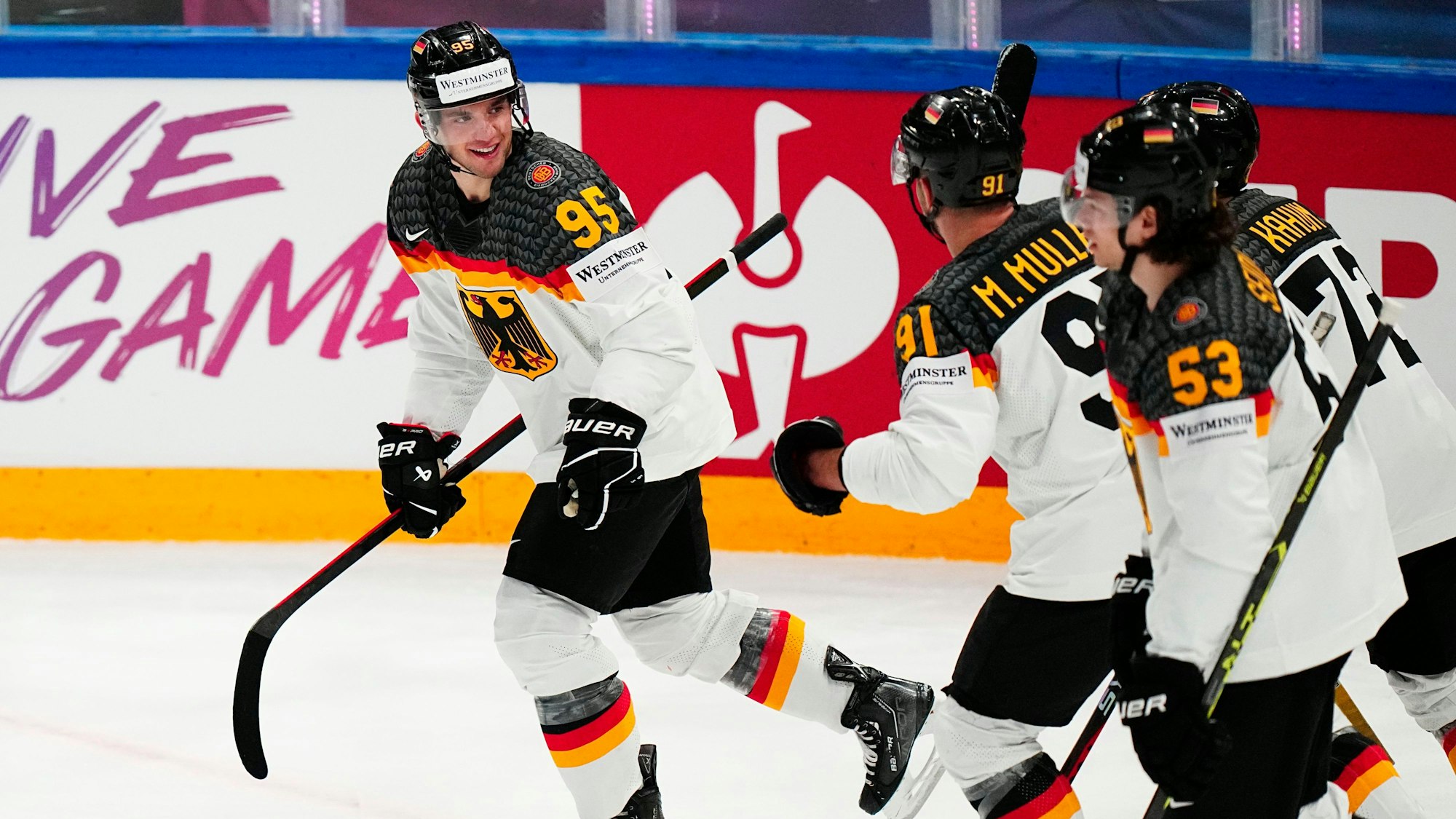 Spieler der deutschen Eishockey-Mannschaft mit Schlägern feiern auf der Spielfläche ein Tor.