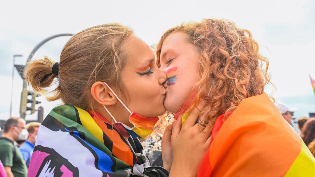 Zwei Frauen küssen sich während des Christopher Street Day 2021.